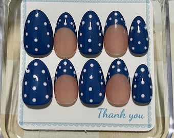May include: A set of ten almond-shaped press-on nails in a clear plastic case. The nails feature a dark blue base with white polka dots, while some nails have a nude-colored French tip design. The display card includes the text Thank you.
