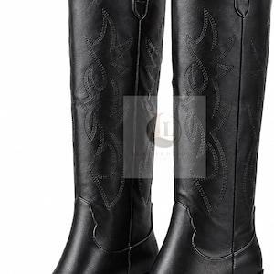 Puede incluir: Un par de botas negras hasta la rodilla con punta afilada, tacón de bloque apilado y patrones de costuras tonales decorativas en la caña. Las botas incluyen tiradores en la parte superior y una superposición de logotipo con el texto LEATHER & LUCK.