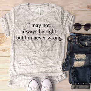 May include: A white t-shirt with a black graphic that reads "I may not always be right, but I'm never wrong." The shirt is paired with blue jeans and white trainers.