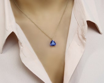 Könnte beinhalten: Eine goldene Kettenkette mit einem blauen tropfenförmigen Anhänger.