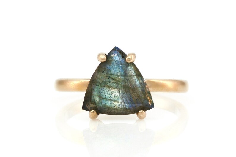 May include: A gold ring with a triangular iridescent labradorite gemstone.