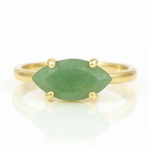 May include: A gold ring with a marquise-shaped green gemstone.
