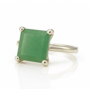 May include: A silver ring with a square green gemstone.