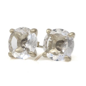May include: A pair of silver stud earrings with clear round cubic zirconia stones.