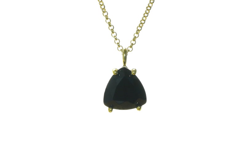 K&ouml;nnte beinhalten: Eine goldene Kettenkette mit einem schwarzen Edelstein-Anh&auml;nger. Der Anh&auml;nger hat eine dreieckige Form mit einem facettierten Schliff.