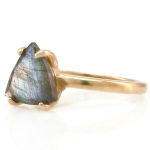 May include: A gold ring with a triangular iridescent labradorite gemstone.