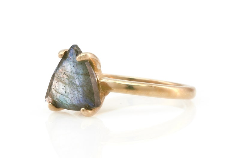 May include: A gold ring with a triangular iridescent labradorite gemstone.