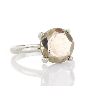 May include: A silver ring with a large, faceted, round, light brown gemstone.