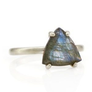 May include: A silver ring with a triangular iridescent labradorite gemstone.