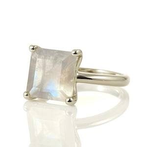 May include: A silver ring featuring a square-shaped moonstone gemstone.