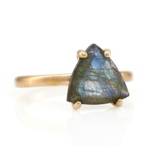 May include: A gold ring with a triangular iridescent labradorite gemstone.