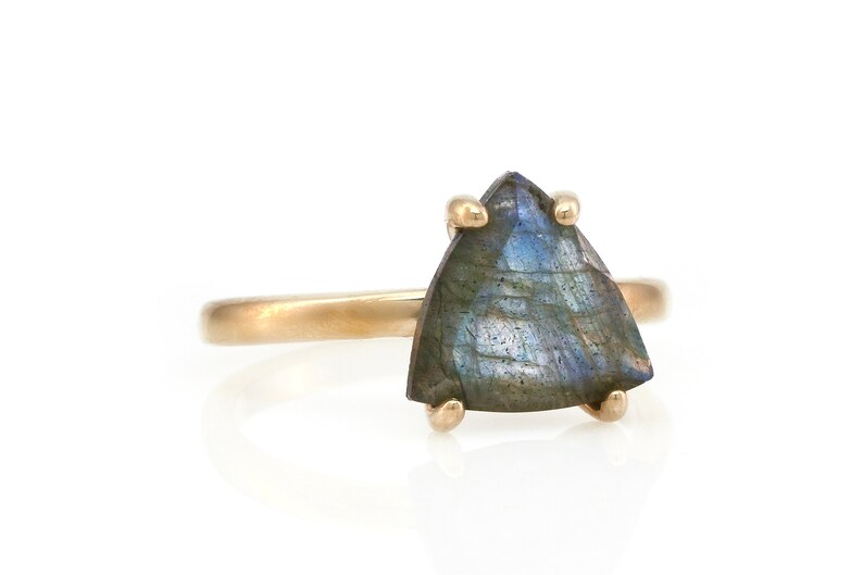 May include: A gold ring with a triangular iridescent labradorite gemstone.