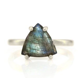 May include: A silver ring with a triangular iridescent labradorite gemstone.