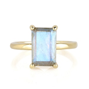May include: A gold ring with a light blue rectangular gemstone.
