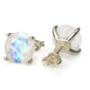 May include: A pair of gold stud earrings with iridescent moonstone gemstones. The earrings have a simple, classic design.