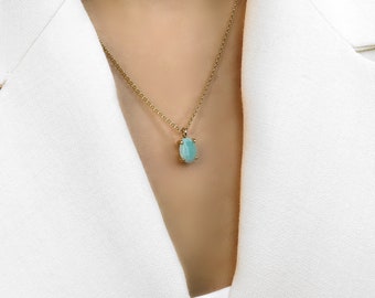 May include: A gold chain necklace with a light blue oval pendant.