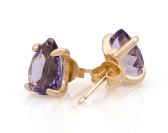 May include: A pair of gold earrings with amethyst pear-shaped gemstones. The earrings have a post back closure.