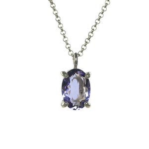 May include: A silver chain necklace with a purple oval gemstone pendant.