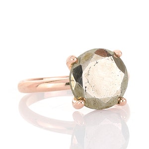 May include: A rose gold ring with a large, faceted, gray gemstone.
