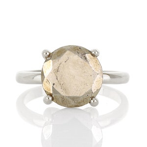 May include: A silver ring with a large, faceted, light brown gemstone.