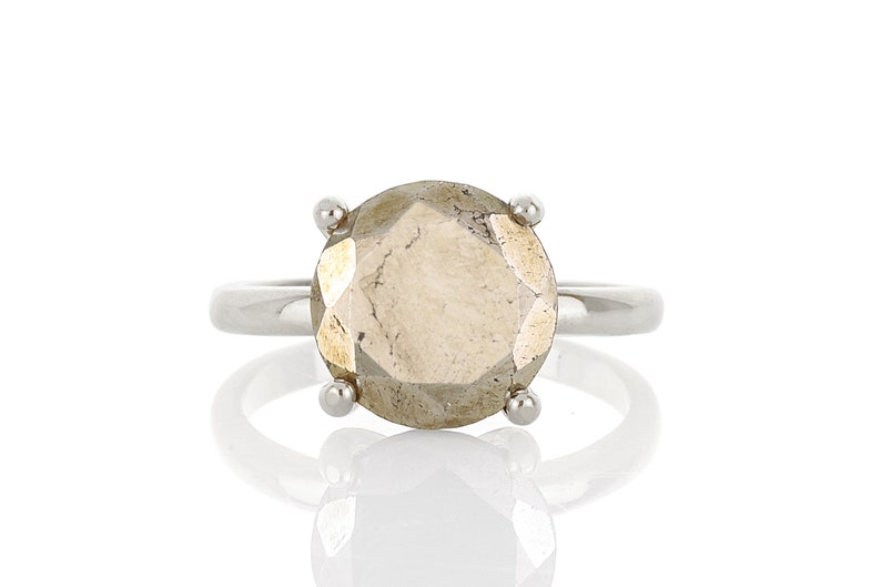May include: A silver ring with a large, faceted, light brown gemstone.