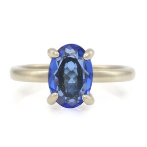 Op de afbeelding: Een zilveren ring met een grote ovale blauwe edelsteen.