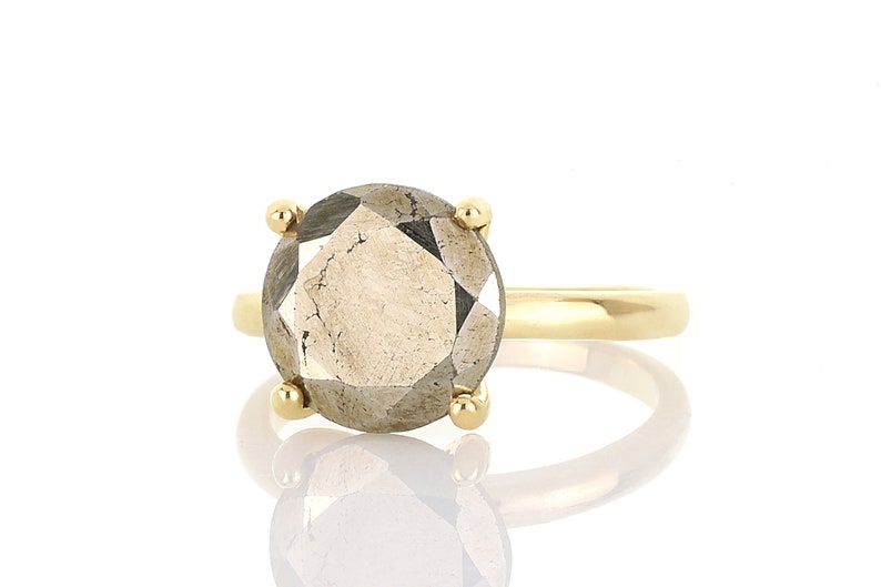 May include: A gold ring with a large, faceted, gray gemstone.