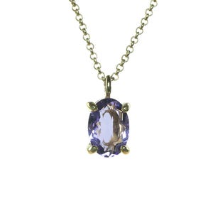 May include: A gold chain necklace with a purple oval gemstone pendant.