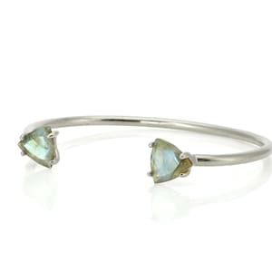 May include: A silver bangle bracelet with two triangular labradorite gemstones.