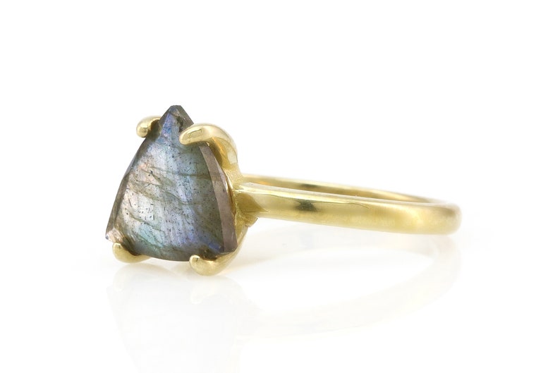 May include: A gold ring with a triangular iridescent labradorite gemstone.