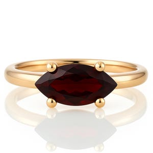 May include: A gold ring with a marquise-shaped red gemstone.