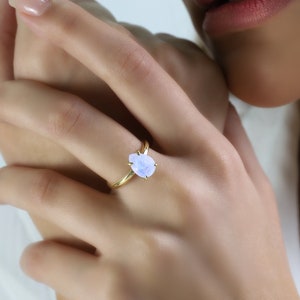 May include: A gold ring with a pear-shaped, light blue gemstone.
