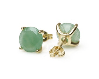 Puede incluir: Un par de pendientes de oro con piedras preciosas verdes. Los pendientes tienen un diseño sencillo y son perfectos para el uso diario.