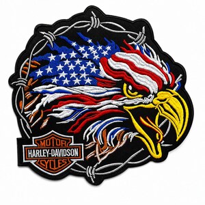 Könnte beinhalten: Ein gestickter Aufnäher mit einem Weißkopfseeadler-Kopf mit gelbem Schnabel, integriert in ein stilisiertes US-Flaggen-Design, umgeben von Stacheldraht, mit dem orange-weiß-schwarzen Harley-Davidson Motor Cycles Logo am unteren Rand.