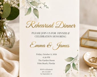 May include: A white rehearsal dinner invitation card featuring gold foil text that reads Rehearsal Dinner, Emma & James, and event details. The design includes watercolor green leaves and small gold dots in the top left and bottom right corners.