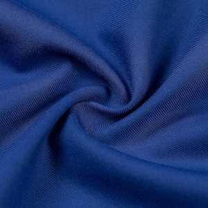 Può includere: Una vista ravvicinata di un tessuto blu reale a tinta unita caratterizzato da una trama finemente a coste. Il materiale è raccolto al centro, creando pieghe morbide e fluide e ombre che mettono in risalto il colore blu intenso e la trama lineare.