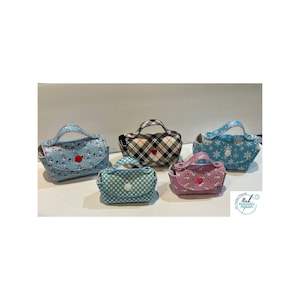 May include: Five small, patterned handbags with handles. Designs include blue snowmen, plaid, white polka dots, pink unicorns, and blue snowflakes. Each bag has a button closure and a small handle.