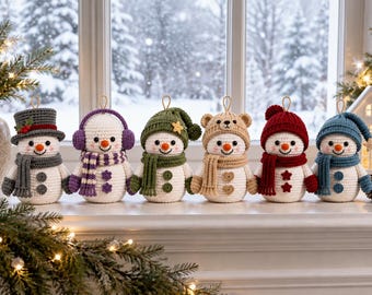 May include: Six crocheted snowman ornaments arranged in a row, each wearing a unique hat and scarf set in colors including gray, purple, green, tan, red, and blue. Each snowman features a white body, orange nose, and two buttons on the front.
