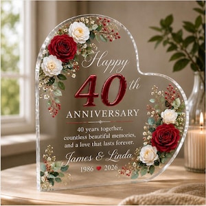 May include: A heart-shaped clear acrylic plaque featuring red and white roses, green leaves, and small white flowers. The text reads: Happy 40th ANNIVERSARY, 40 years together, countless beautiful memories, and a love that lasts forever. James & Linda 1986 2026.