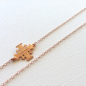 May include: A gold-toned necklace with a delicate chain and a detailed cross pendant.