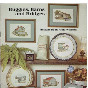 May include: A collection of cross-stitch patterns featuring country scenes, including barns, bridges, buggies, and a grist mill. The patterns are framed and displayed on a shelf with other decorative items. The title of the collection is "Buggies, Barns and Bridges" and the designer is Barbara Weiford. The price is $4.95.
