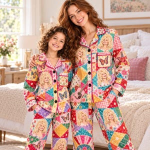 May include: Matching long-sleeve button-down pyjama sets featuring a colourful patchwork quilt pattern. The fabric displays repeating images of Dolly Parton, acoustic guitars, and butterflies in shades of pink, yellow, blue, and green.