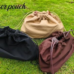 May include: Three drawstring pouches labeled inner pouch, featuring one black, one beige, and one dark brown bag. Each pouch has a gathered top closure with matching cord strings and small leather-like tabs at the cinch points for secure closing.