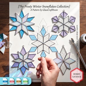 May include: Stained glass snowflake ornaments from The Frosty Winter Snowflakes Collection by GlassCraftRoom. The set includes five geometric star-shaped pieces in blue, purple, and iridescent white glass with metal solder lines and hanging loops.