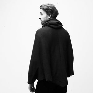 May include: A black hooded poncho with a long, flowing design. The poncho is made of a soft, comfortable fabric and has a relaxed fit.