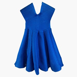 May include: A blue knit dress with a V-neck and short sleeves. The dress has a flared skirt and a fitted bodice.