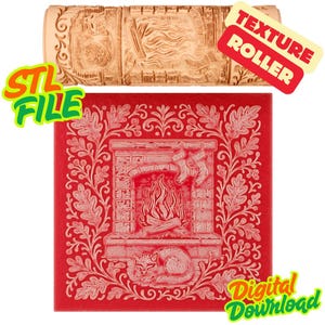 Puede incluir: Un rodillo de textura cilíndrico beige con una escena de chimenea grabada con un gato, troncos y calcetines. Debajo, un azulejo cuadrado rojo muestra el mismo patrón en relieve, rodeado por un borde de hojas de roble y bayas.