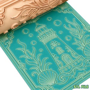 May include: A light peach-colored textured rolling pin positioned above a teal-colored flat surface. The surface features an embossed design of a lighthouse surrounded by seaweed, seashells, and bubbles. The text STL FILE is visible.
