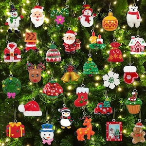 May include: A collection of assorted Christmas tree ornaments featuring various holiday figures including snowmen, Santa Claus, reindeer, a penguin, a gingerbread man, gift boxes, stockings, and festive symbols like wreaths and snowflakes.