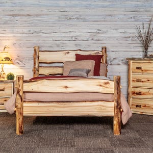 May include: A rustic bedroom set featuring a wooden bed frame, nightstand, and dresser. The bed has a natural wood headboard and footboard. The nightstand has a lamp with a bear design. The dresser has four drawers. The set is made of light-colored wood.
